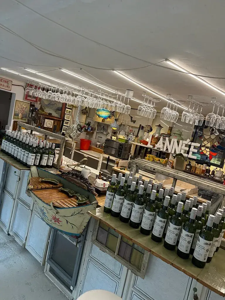 Die Bar der Garage mit Weinflaschen, Gläsern und einem Boot als Tresen