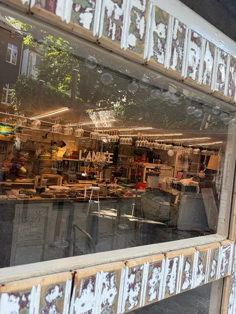 Blick durch ein altes Fenster in die Garage mit hängenden Gläsern