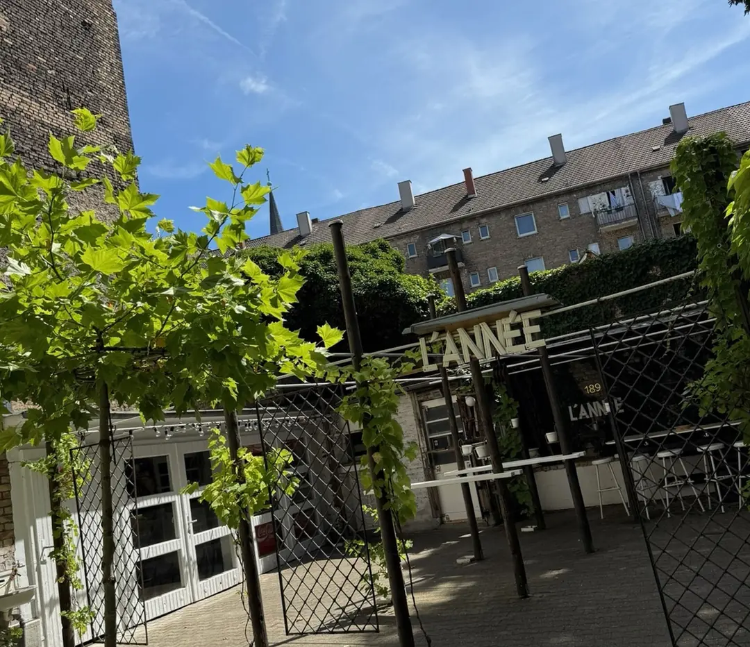 Der Innenhof der Garage im Jungbusch mit Weinlaub, Spalier und dem L’ANNÉE-Schriftzug