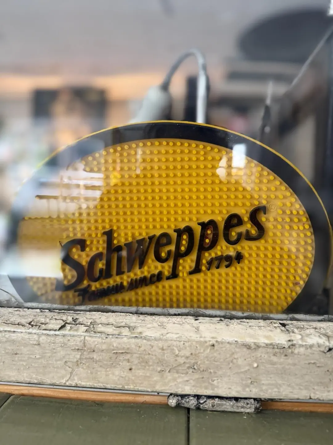 Ein altes gelbes Schweppes-Werbeschild